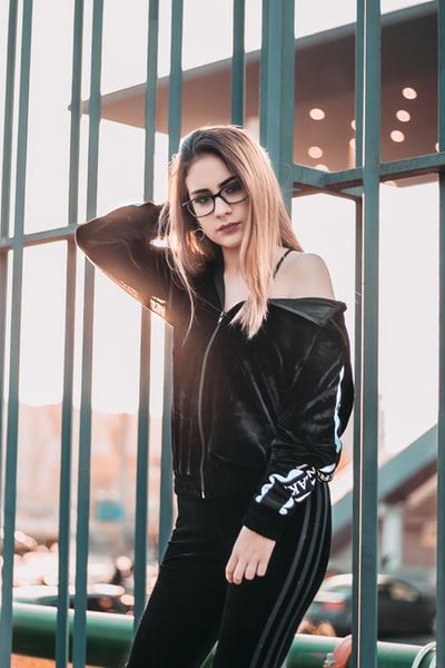 眼镜的女人靠在绿色金属框架在白天
